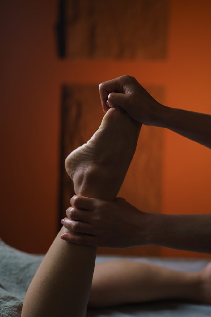 Therapist stretching a client’s foot during a Thai massage